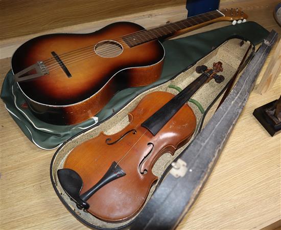 A cased violin, bow and a guitar